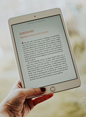 hand holding iPad displaying page from ebook